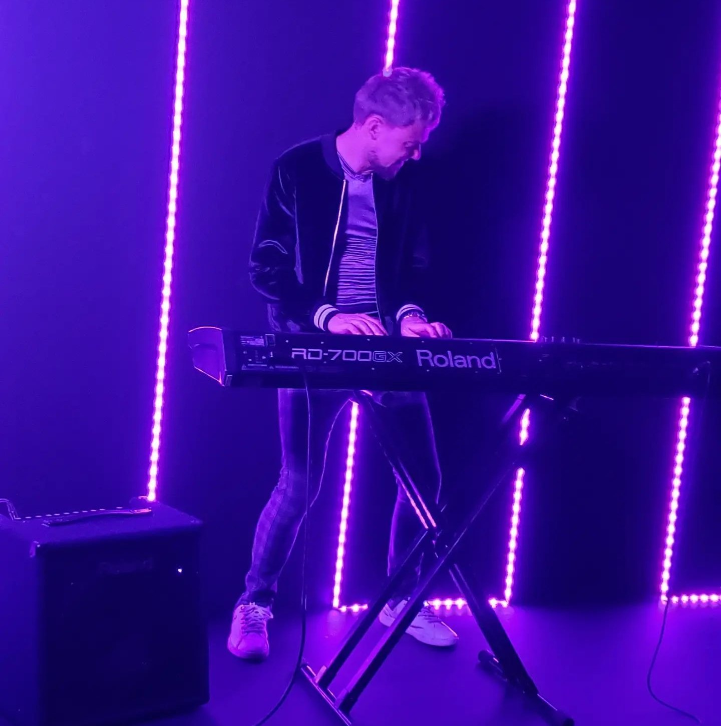 Austin Kimble performing on keyboard under purple stage lights